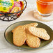 A plate with a stack of Nabisco belVita Cinnamon Brown Sugar Breakfast Biscuits next to a cup of tea on a table.