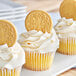 A close-up of a cupcake with a Nabisco Oreo cookie on top.