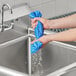 A person holding a Lavex blue cooling towel.
