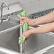 A person washing their hands with a Lavex lime green cooling towel.