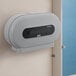 A grey Lavex VersaHub WiFi-enabled double roll jumbo toilet paper dispenser on a wall.