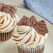 Milk chocolate covered mini graham crackers in a close up dessert with white frosting and chocolate squares.