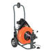 A close-up of a black and orange General Pipe Cleaners Speedrooter XL drain cleaning machine.