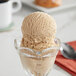 A scoop of I. Rice Dulce de Leche hard serve ice cream in a glass bowl.