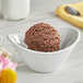 A bowl of I. Rice Rich double chocolate ice cream with a spoon.