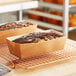Two Tielman Bake-Well corrugated Kraft paper loaf molds filled with bread on a table.