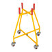 A yellow and red steel dolly with wheels for a Vestil bucket.