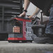 A man using a Mr. Heater Buddy FLEX portable radiant heater to warm up a room.