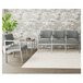 A Lesro Lenox steel open house asteroid fabric 3-seat sofa with center arms in a lounge area with a plant on the table.