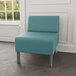 A Lesro Luxe Lounge Series blue vinyl guest chair with steel legs in a lounge area.