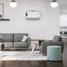 A living room with a grey couch and white chairs.