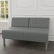 A Lesro Luxe Lounge loveseat with steel legs in a lounge area.