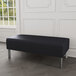 A Lesro black vinyl bench with steel legs in a lounge area.