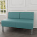 A Lesro Luxe Lounge Series blue vinyl loveseat with steel legs in a lounge area.