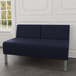 A Lesro Luxe Lounge Series blue vinyl loveseat with steel legs in a lounge area.