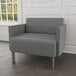 A Lesro Luxe Lounge bariatric chair with steel legs in gray fabric in a lounge area.