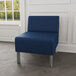 A Lesro Luxe Lounge blue vinyl chair with steel legs in a lounge area.