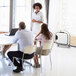 A group of people sitting around a table with a white Fellowes Array air purifier on it.