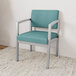 A blue Lesro Lenox guest chair with a silver frame against a white wall.