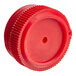 A red plastic cap with a hole on a white background.