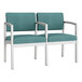 Two Lesro Lenox steel loveseats with teal vinyl and white legs.