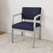 A Lesro Lenox steel arm chair with navy fabric and armrests.