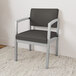 A Lesro Lenox steel guest arm chair with black vinyl cushion.