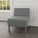 A Lesro Luxe Lounge guest chair with steel legs upholstered in grey fabric in a lounge area.