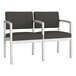 A Lesro Lenox steel loveseat in charcoal vinyl with center armrest.