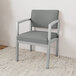 A Lesro Lenox steel guest arm chair with Asteroid fabric in front of a white wall.