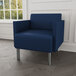 A Lesro Luxe Lounge blue vinyl guest chair in a lounge area.