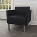 A Lesro Luxe black vinyl arm chair in a lounge area.