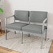 A Lesro Lenox steel loveseat and chair in gray fabric with armrests on a rug.