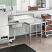 A stainless steel L-shape dishtable with a sink.