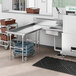 A Regency stainless steel soiled dishtable on a counter in a kitchen with a stainless steel sink.
