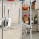 A white metal grid shelf with Choice 10" round skimmers hanging from it.