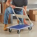 A man using a Lavex steel folding platform truck to move items.