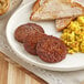 A plate with Jack & Annie's vegan plant-based sausage patties, eggs, and toast on it.