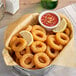 A bowl of Beleaf Plant-Based Vegan Calamari with red sauce and a lemon wedge.