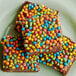 A group of brownies with colorful candies on top.