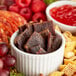 A bowl of Bronco Billy's beef jerky and other snacks on a table.