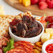 A plate of Bronco Billy's Peppered Beef Jerky with fruit and crackers.