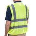 A man wearing a Cordova lime high visibility safety vest with hook and loop closure over a black shirt.