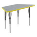 A grey and yellow trapezoid-shaped table with black legs and yellow trim.