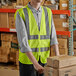 A man wearing a Lavex lime green high visibility safety vest standing in a warehouse.