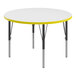 A white Correll round activity table with yellow T-mold and black legs.