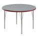 A round gray granite activity table with red T-mold on the edge.