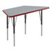A grey trapezoid activity table with black legs and red trim.