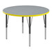 A Correll round activity table with a gray high-pressure laminate top and yellow edge.