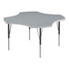 A grey table with a white and grey clover shaped top and black legs.